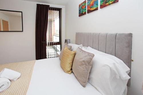 特尔福德Autumn Heights Apartments的一间卧室配有带白色床单和枕头的床。