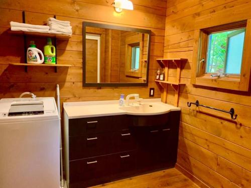 白马村白馬のスキー場まで４分お洒落なログハウス『白馬 MAMMOTH HOUSE』的一间带水槽和镜子的浴室