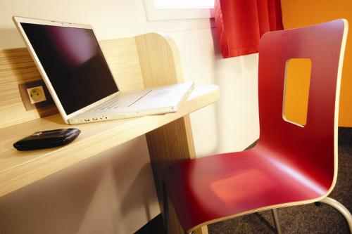 伊斯特尔普瑞米尔伊斯特尔经典酒店的一张桌子上的笔记本电脑和红色椅子