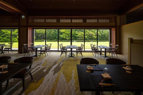 彦根市Biwafront Hikone的用餐室配有桌椅和大窗户