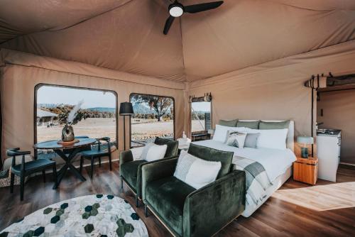 CaperteeWildnest Farmstay的帐篷内的卧室,配有一张床和一张桌子
