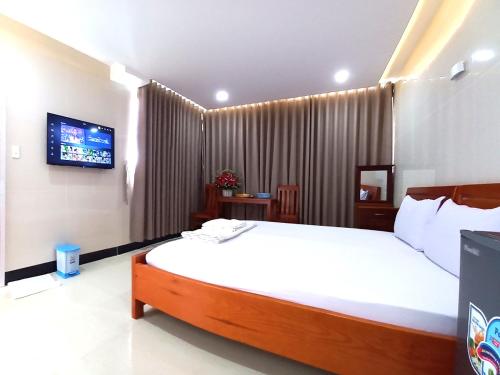 Dĩ AnKHÁCH SẠN CÚC PHƯƠNG (CÚC PHƯƠNG HOTEL)的一间带大床和电视的卧室