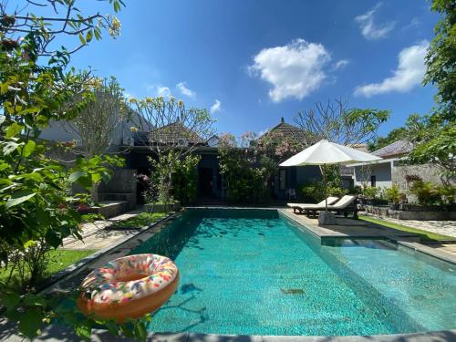 乌鲁瓦图阿莎娜酒店的一座房子前面带浮动的游泳池