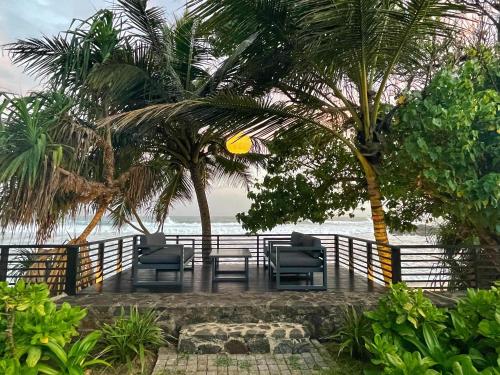 乌纳瓦图纳Elysium的海滩上带椅子和棕榈树的庭院