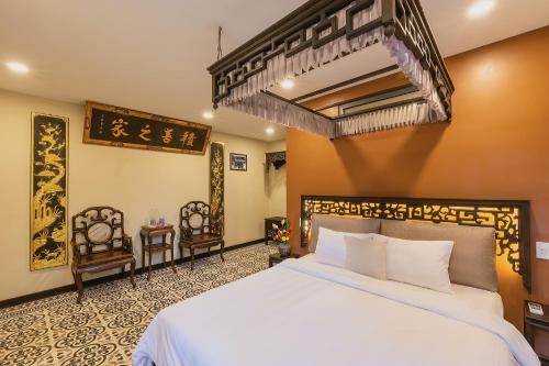 顺化HueNam Residence的卧室配有一张白色大床和两把椅子
