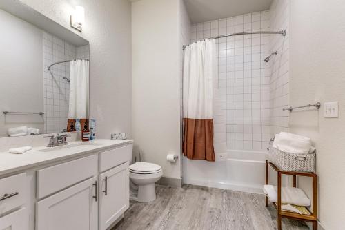 圣安东尼奥Lush Downtown Condo on RiverWalk #1100的白色的浴室设有卫生间和水槽。