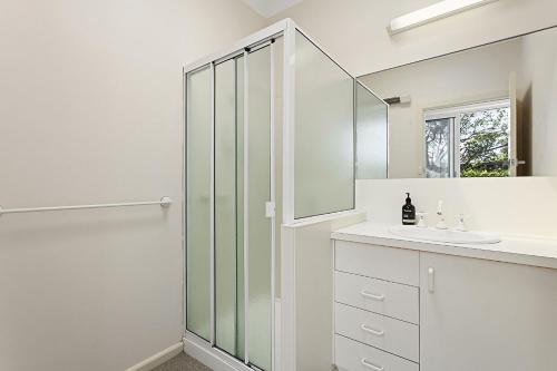 伯恩特隆斯代尔Curragundi的带淋浴和盥洗盆的白色浴室
