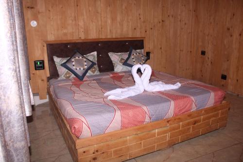 TisaHotel Mannat Sach Pass的一间卧室配有一张白色天鹅床