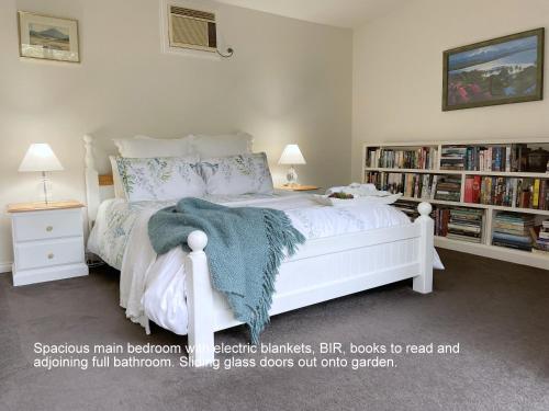 因沃洛什Bayview Studio的卧室配有白色的床和书架