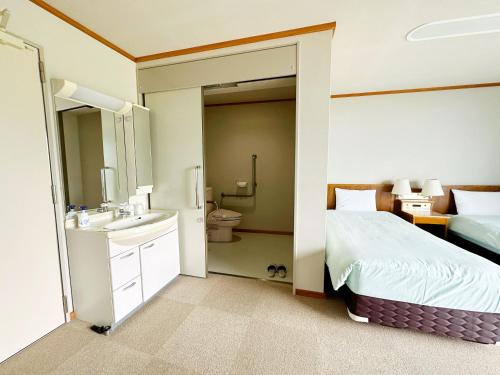 京丹后市森林公園スイス村 風のがっこう京都的一间卧室配有一张床,浴室设有水槽