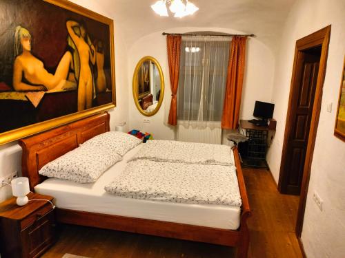 班斯卡-比斯特里察Paracelsus house的卧室配有一张床,墙上挂有绘画作品