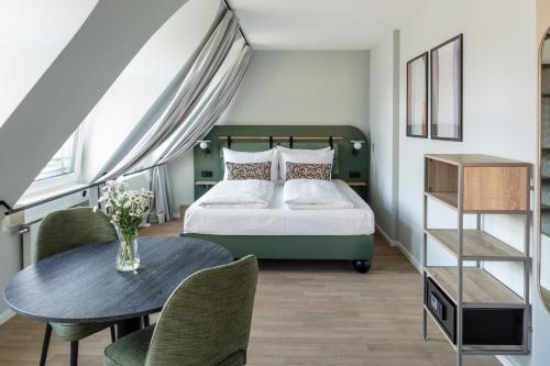 慕尼黑numa I Blend Apartments的卧室配有一张床和一张桌子及椅子