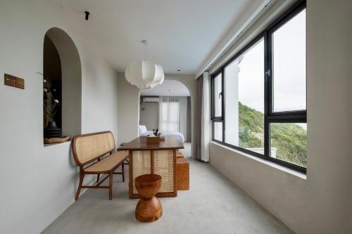 舟山听涧·登观海景Villa设计师酒店的客房设有桌子、椅子和窗户。