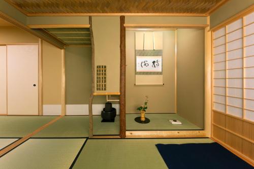 京都Towa Ryokan的一间设有绿色地板和窗户的客房