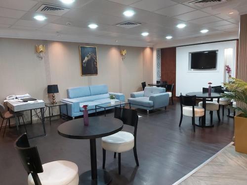 阿吉曼阿拉伯公寓酒店的一间设有蓝色长沙发和桌椅的等候室