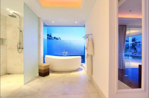 苏梅岛White Tiger Villa的浴室配有白色浴缸和蓝色的墙壁