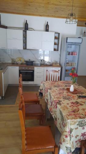 佩尔梅特Bujtina Lugina e vjosës的带桌椅的厨房以及带桌子和台面的厨房