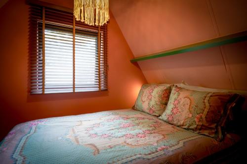 拉纳肯Boshuisje Pinus的一间小卧室,配有床和窗户