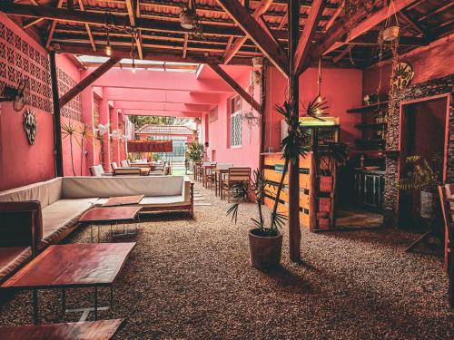 马普托La Casa Moz的一间设有粉红色墙壁、一张沙发和桌子的房间