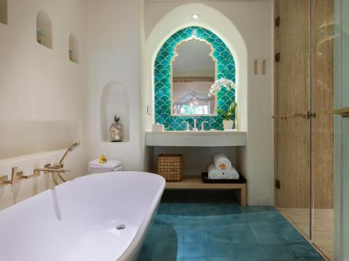 勒吉安巴厘曼迪拉海滩Spa度假酒店的带浴缸和镜子的浴室