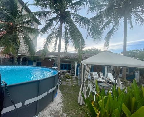 珍南海滩Dar Yasmine Motel的一座带游泳池和棕榈树的房子