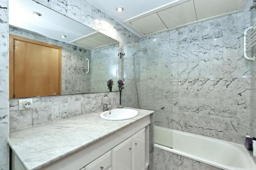 赫罗纳Apartament Sant Feliu的一间带水槽、浴缸和镜子的浴室