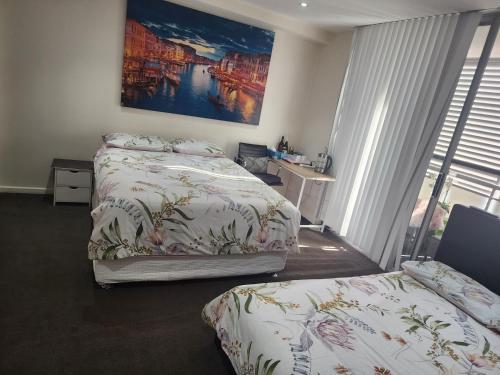 悉尼Parramatta Shared Apartment的一间卧室设有两张床,墙上挂着一幅画