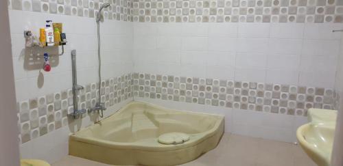 KalasanKumara Homestay Jogja的一间位于客房角落的带浴缸的浴室