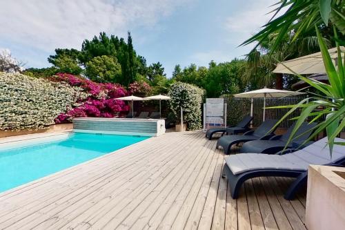 维琪奥港Villas CALA CORSA - 3 et 4 Chambres - CALA ROSSA Porto-Vecchio - Villas entièrement Climatisées avec Piscine Chauffée partagée et Piscines Privées - Internet gratuit的木制甲板上配有椅子和遮阳伞的游泳池