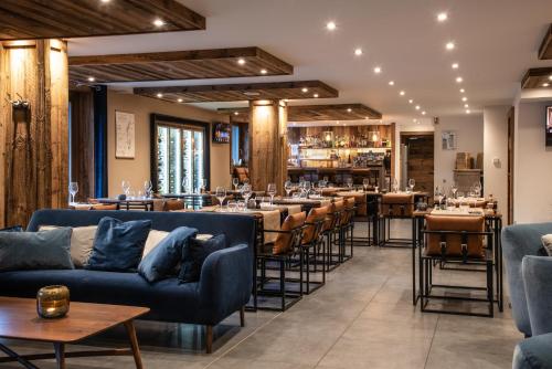 莱热Annapurna by Alpine Residences的一间设有蓝色沙发和桌子的餐厅和一间酒吧