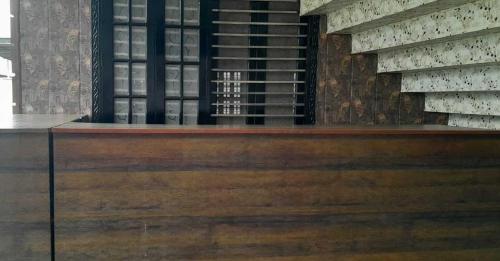 勒克瑙OYO Flagship Tirupati Lawn And Hotel的客房设有葡萄酒架和木桌。