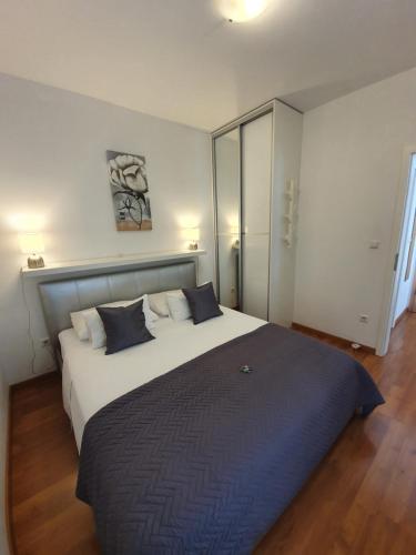 穆泰尔岛马蒂公寓酒店的卧室配有带蓝色枕头的大型白色床