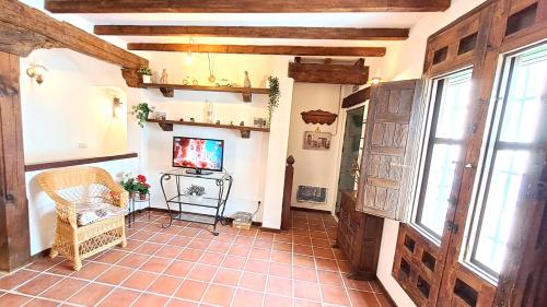 钦琼Casa Rural Casasola的客厅铺有瓷砖地板,配有电视。