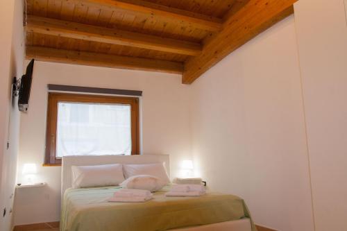 科拉托AMORE SE-WOODEN APARTMENTS的一间卧室配有一张床,上面有两条毛巾