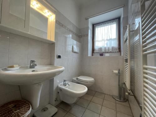平佐洛Appartamenti Casa Albi的白色的浴室设有水槽和卫生间。