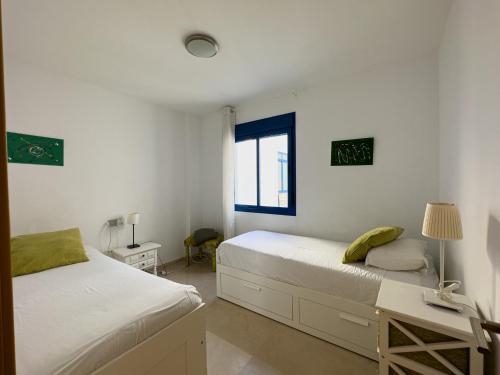 托罗克斯科斯塔Penthouse by the beach的一间卧室设有两张床、一张桌子和一个窗口。