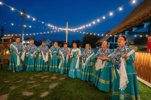 茹里洛夫卡Pensiunea Cuplu Călător的一群身穿蓝色连衣裙的女人站在灯下