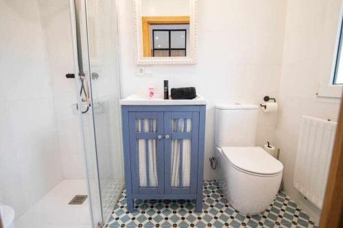 MontorioCasa Rural Hacienda Montorio的浴室设有蓝色橱柜,位于厕所旁边
