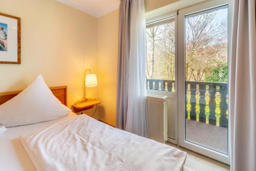 宁布雷希特比热巴赫尔酒店的一间卧室设有一张床和一个阳台的窗户。