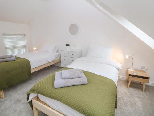 谢菲尔德Potters Cottage的一间卧室配有两张床和一张带毛巾的桌子
