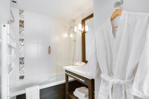 南特太阳城七城市套房大厦的白色的浴室设有水槽和淋浴。