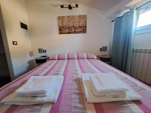 摩德纳Alloggiamo的一间卧室配有一张床,上面有两条毛巾