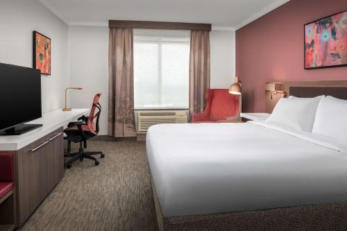 米苏拉米苏拉希尔顿花园酒店的酒店客房配有一张床、一张书桌和一台电视。