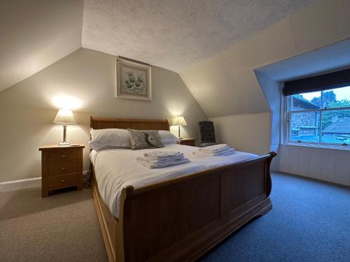 StrathtayRed Squirrel Cottage的一间卧室设有一张大床和一个窗户。
