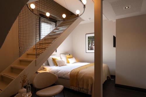 法尔肯堡Hotel Kint的一间卧室配有一张床,楼梯配有一张床和楼梯栏杆