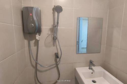 莎阿南SGA SuriaJelutong的带淋浴的浴室,配有水槽和镜子