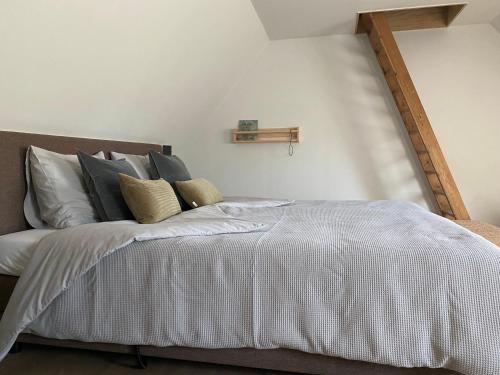 AlbergenB&B Het Zwarte Schaap的一间卧室配有带白色床单和枕头的床。