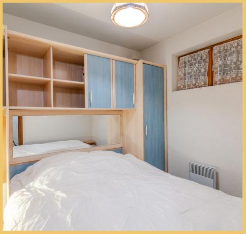 莫尔济讷Appartement T2 Téléphérique de NYON Morzine的一间卧室配有蓝色橱柜和一张床