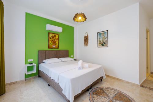安塔利亚Mel Town的一间卧室配有一张带绿色墙壁的床