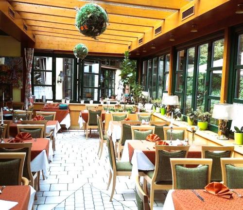 格拉茨Hotel Restaurant - Häuserl im Wald Graz的餐厅设有桌椅和窗户。